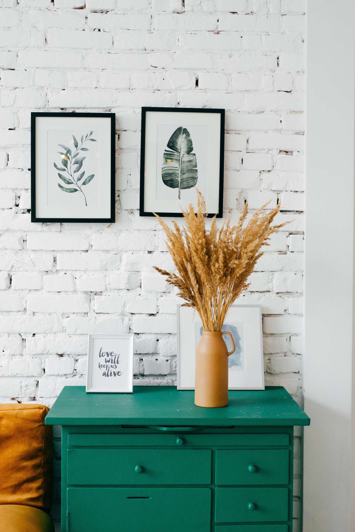 A green table with two pictures on the wall