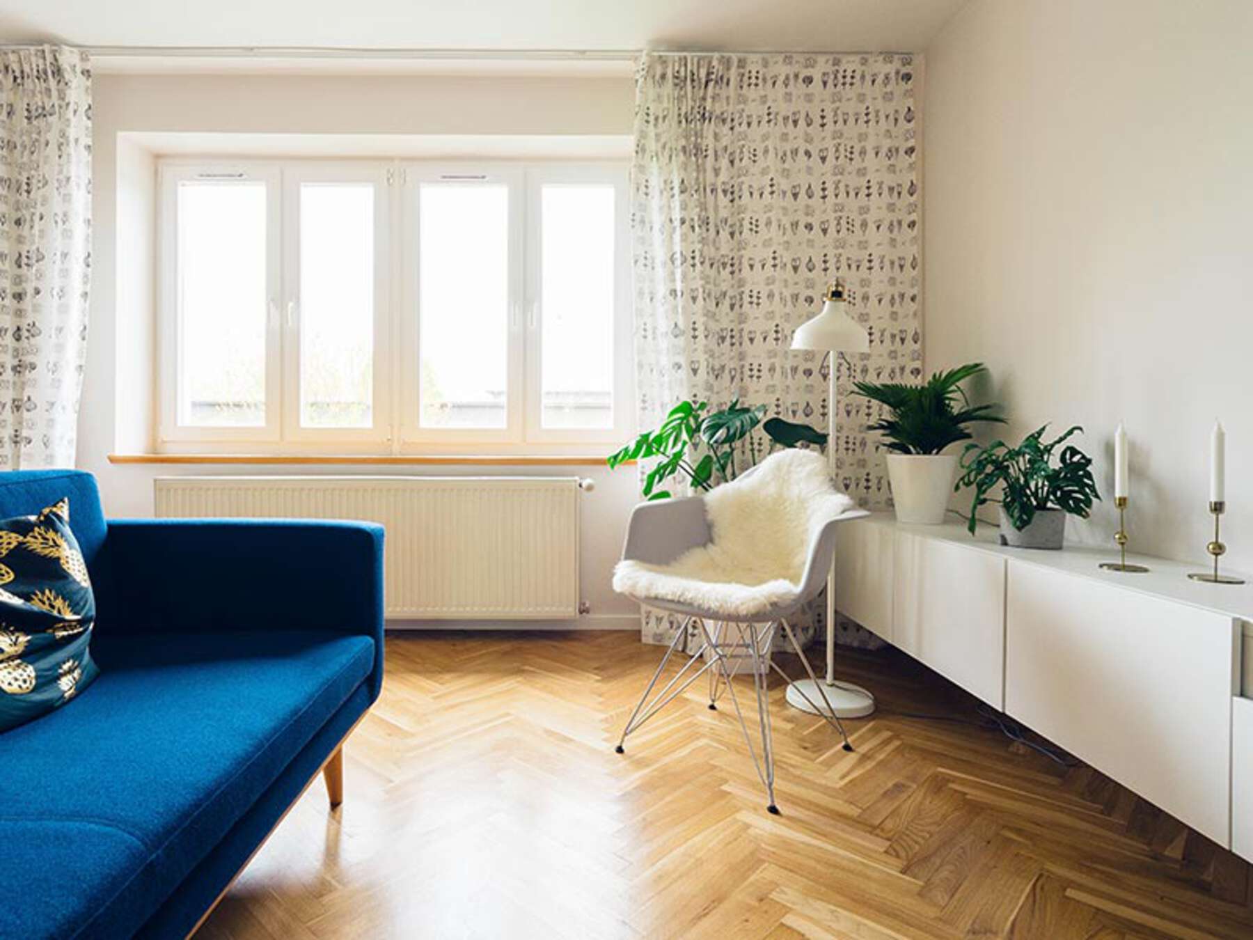 A living room with a blue couch and white chair