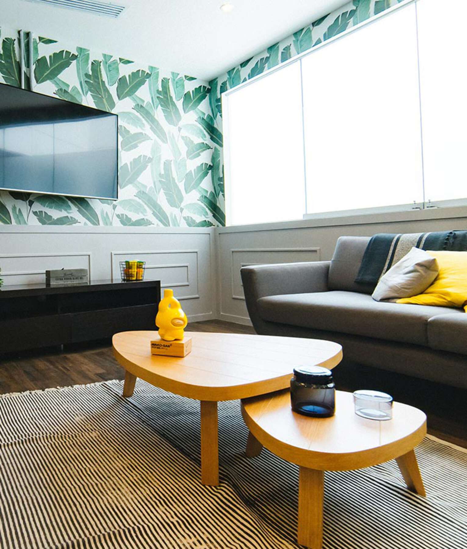 A living room with two tables and a tv