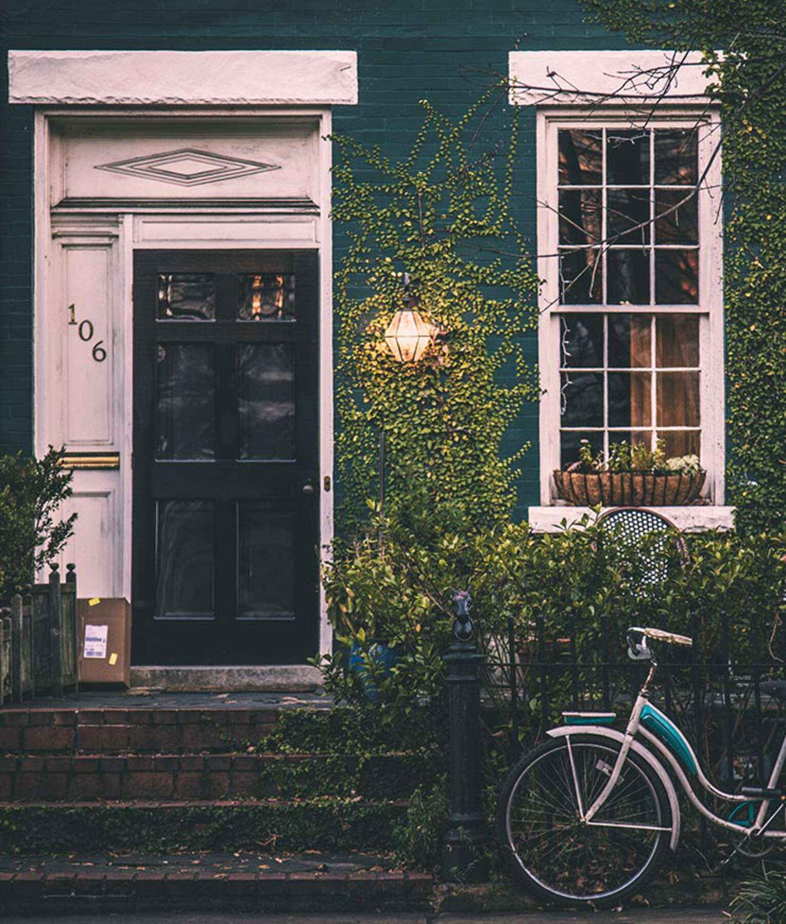 A bicycle parked in front of a green house.